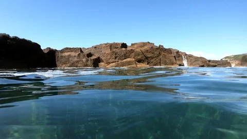 Wave crashing onto the rocks on a sunny day. Sardinia, Italy Stock Footage