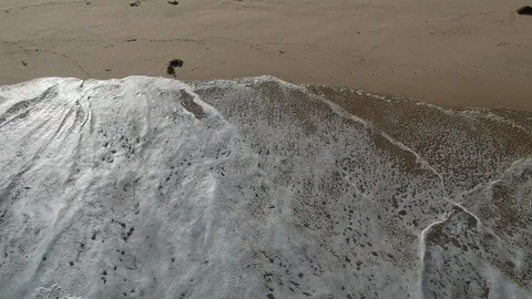Wave drawing back on a sandy beach top shot Australia Stock Footage 122237506