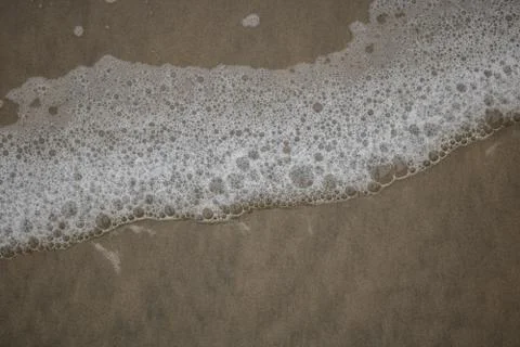 Wave foam on the sand 스톡 사진