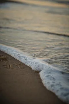 Wave with foam at sunset Stock Photos
