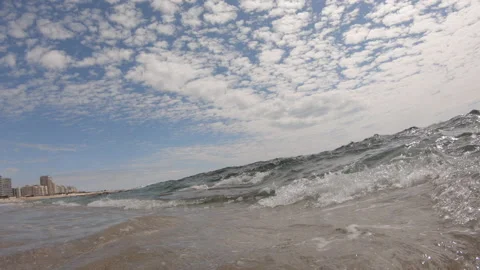 A wave forms on ocean and brakes on shore splashing over camera Stock Footage 132936100