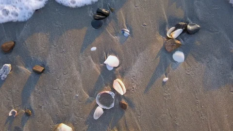 A wave gently washes over the sandy shoreline Stock Footage 108198148