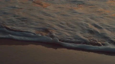 A wave goes up the beach at sunset Video stock 144574990