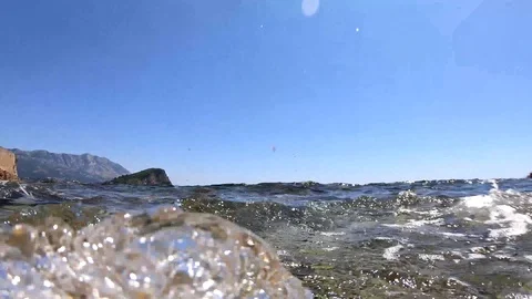 The wave goes to the camera and hits the lens. On the horizon is an island Stock Footage 111913762