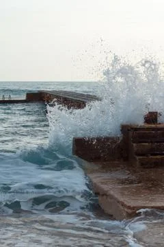 Wave hits the pier Stock Photos
