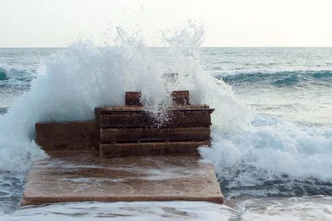 Wave hits the pier Stock Photos