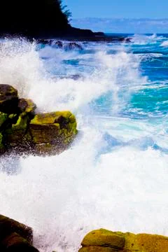 A WAVE HITS ROCKS  Stock Photos