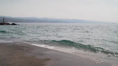 Wave hitting concrete shore with statue in the background 1 Stock Footage 277719969