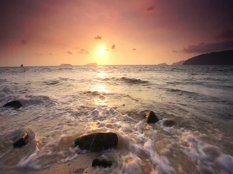 Wave hitting the rock with dramatic sunset at background Stock Footage 103823732