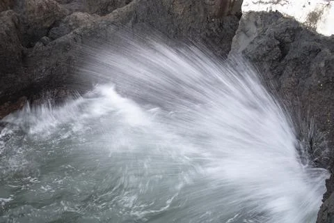 Wave hitting a rock Stock Photos