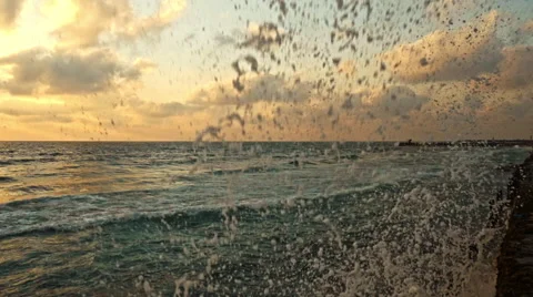 Wave hitting the wall with splash in the sunset Stock Footage 65056839