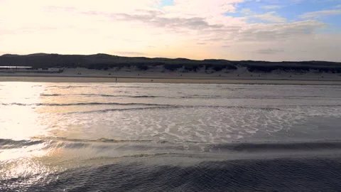Wave moves towards the shore in the backdrop of a backyard sun. Netherlands Stock Footage 97352791