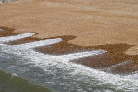 Wave patterns on shingle beach. Brighton. England Stock Photos