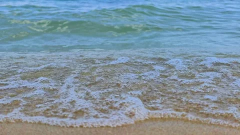 Wave rolls in, foamy splash touches sand Stock Footage 341764985