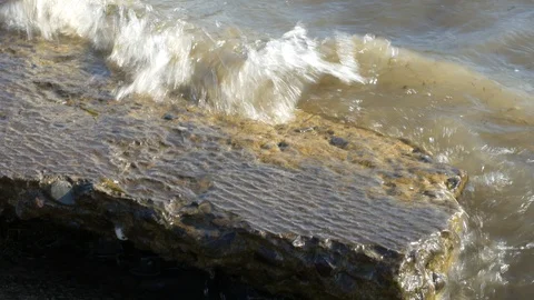A wave rolls over the stone.Close up Stock Footage 118449333