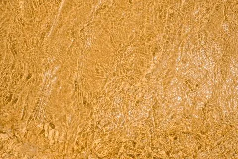 Wave on the sand beach background. sand and water texture. transparent water  Stock Photos