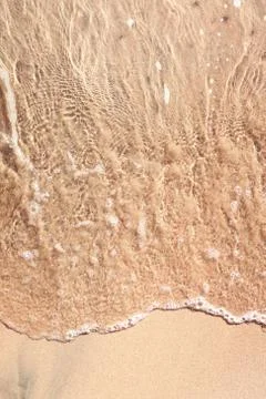 Wave on sandy beach Stock Photos