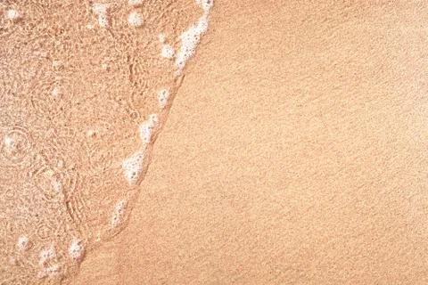 Wave on sandy beach Stock Photos