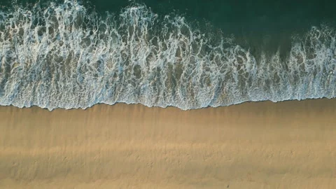 Wave on a sandy beach washes away the sand aerial top down view Stock Footage 242179022