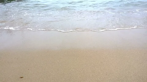 Wave scouring out footprints Stock Footage 78832294