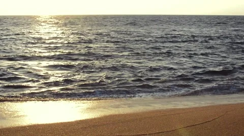 Wave of the sea on the sandy beach at sunset Видео 49672359