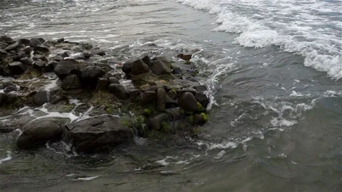 Wave in slow motion runs onto a rocky seashore Stock Footage 122561432