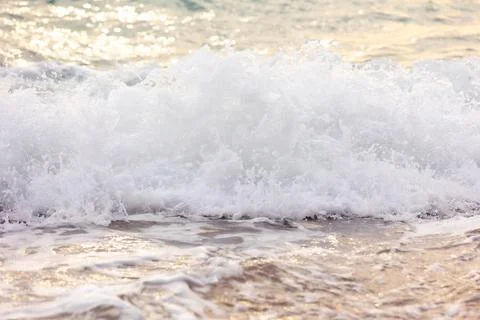 Wave splashes close-up, sunset sea background Stock Photos