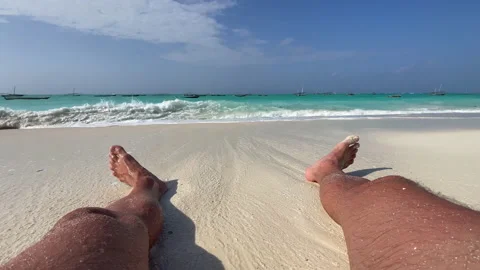 Wave splashing covering camera POV hairy legs footage of a man looking at ocean  Vidéo 154370040