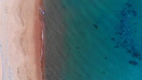 Wave splashing Overflight Along orange sandy Coastline,Turquoise water 4k Aerial Stock Footage 105137488