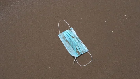 A wave takes a face mask on the beach Vídeo Stock 131572208