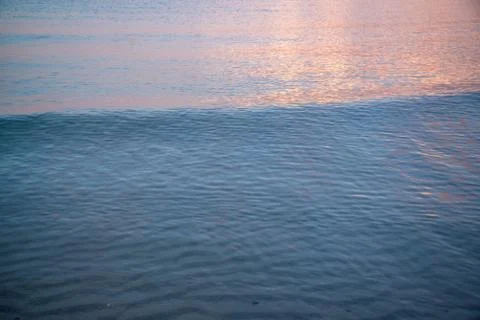 Wave texture at sunset Stock Photos