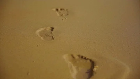 The wave washes away the tracks on the seashore Stock Footage 98058415