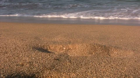 Wave washes up beach right up to lens Stock Footage 1083544
