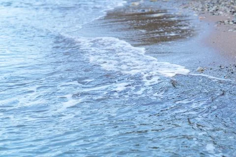 A wave washes a pebble beach Stock Photos