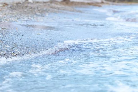 A wave washes a pebble beach Stock Photos