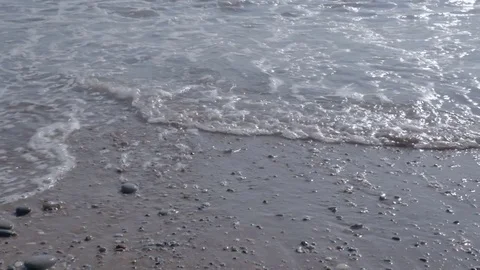 Wave with white foam. Beach with sand and pebbles. Stock Footage 80449837