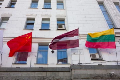 Waved national flags on facade wall with windows. Government or business buil Stock-Fotos
