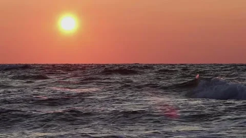 A Waved Sea In The Rays Of Sunset. A Fiery Sun And An Orange Sky Stock Footage 160864825