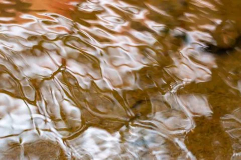 Waved water surface pattern with yellow sandy bottom. Stock Photos