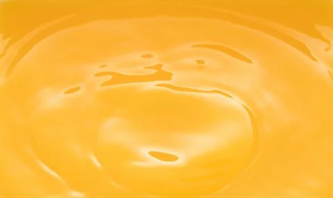 The waves after a few drops of orange juice. Stock Photos