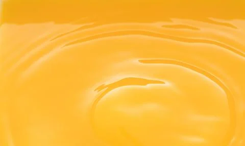 The waves after a few drops of orange juice. Stock Photos