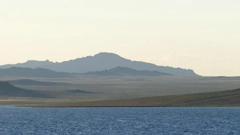 The waves against the backdrop of the mountains and the pale blue sky. Stock Footage 79688104