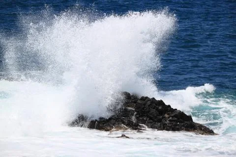 Waves against a cliff Stock Photos