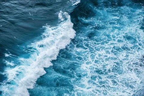Waves and blue water as a background. View from high rock at the ocean surfac Stock Photos