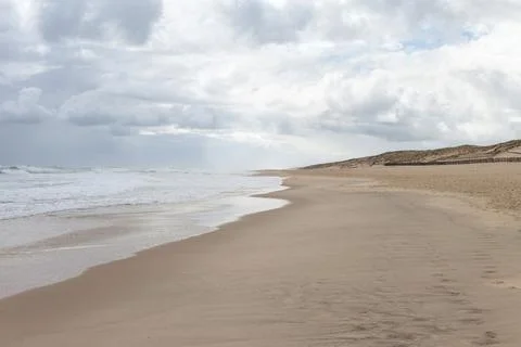 Waves and cloudy skies in a beach landscape Stock Photos