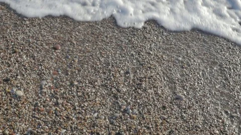 Waves and foam on the beach. Pebble stones by the sea. Stock Footage 80048769