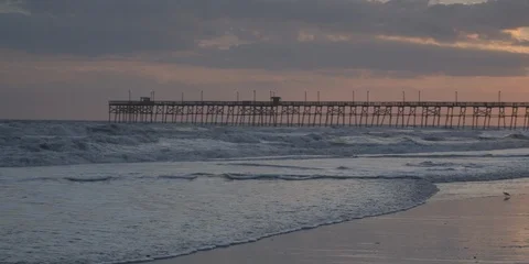 Waves and pier in background at sunset NC coast Stock Footage 103492263