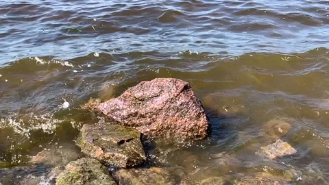 Waves and stone on the sea shore in slow motion Stock Footage 144476900