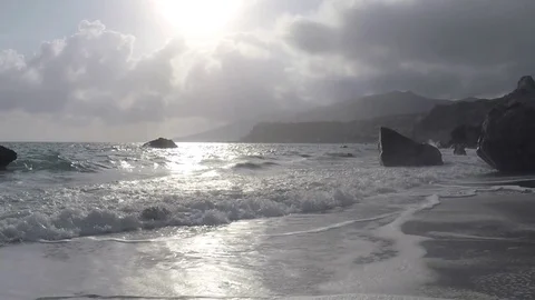 Waves and sun reflect in an Exotic Beach Stock Footage 75888179