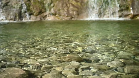 Waves and sunlight effects in the pool created by a waterfall (slow motion) Stock-Footage 219645254